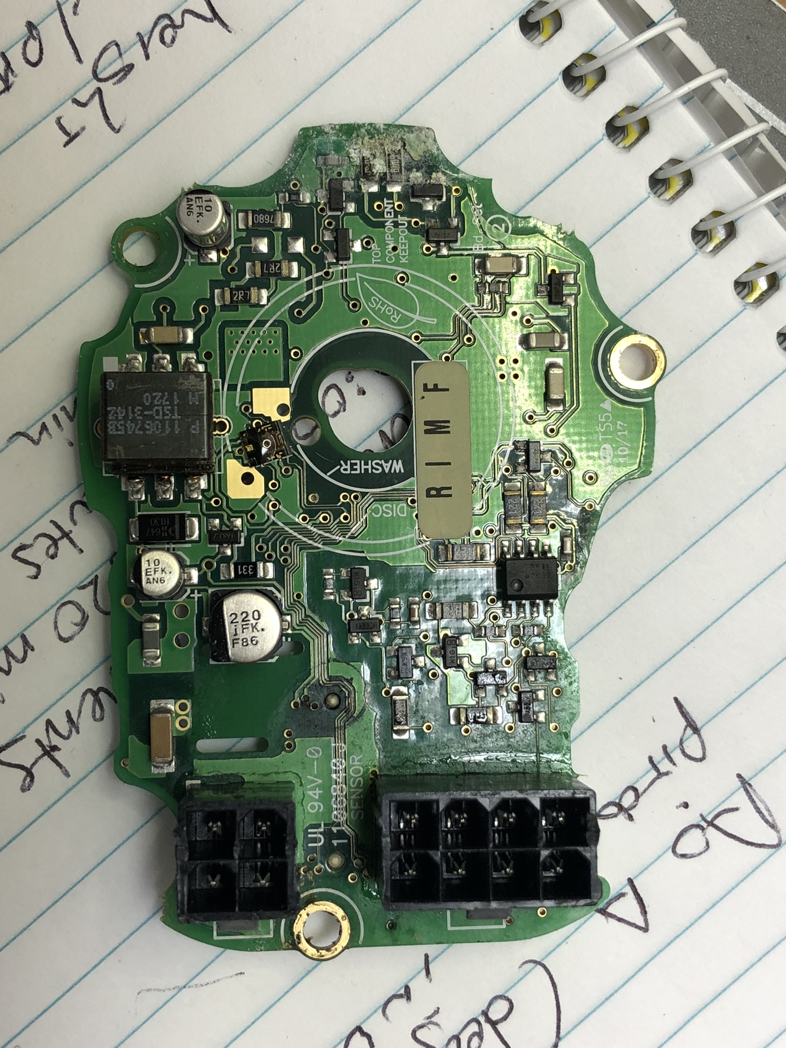 Internal PCB on page of paper, hole cutout for encoder shaft, black Molex Microfit connectors for IO and power