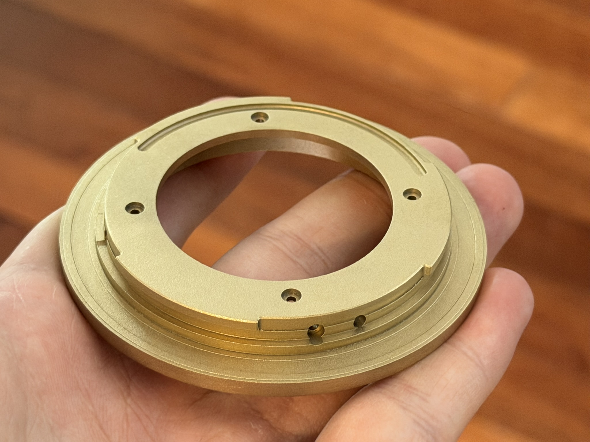 Machined brass lens mount adapter in hand